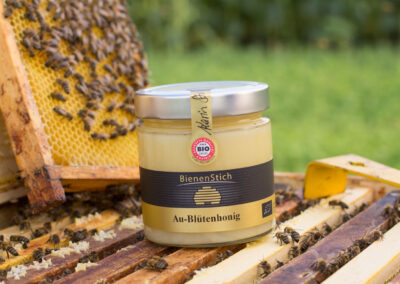 Dieses Bild zeigt ein 500g Glas Aublütenhonig der Imkerei BienenStich aus Manhartsbrunn, Österreich. BienenStich ist ein kleiner Familienbetrieb in der Nähe von Wien und es wird in der Imkerei hochwertiger BIO-Honig hergestellt.